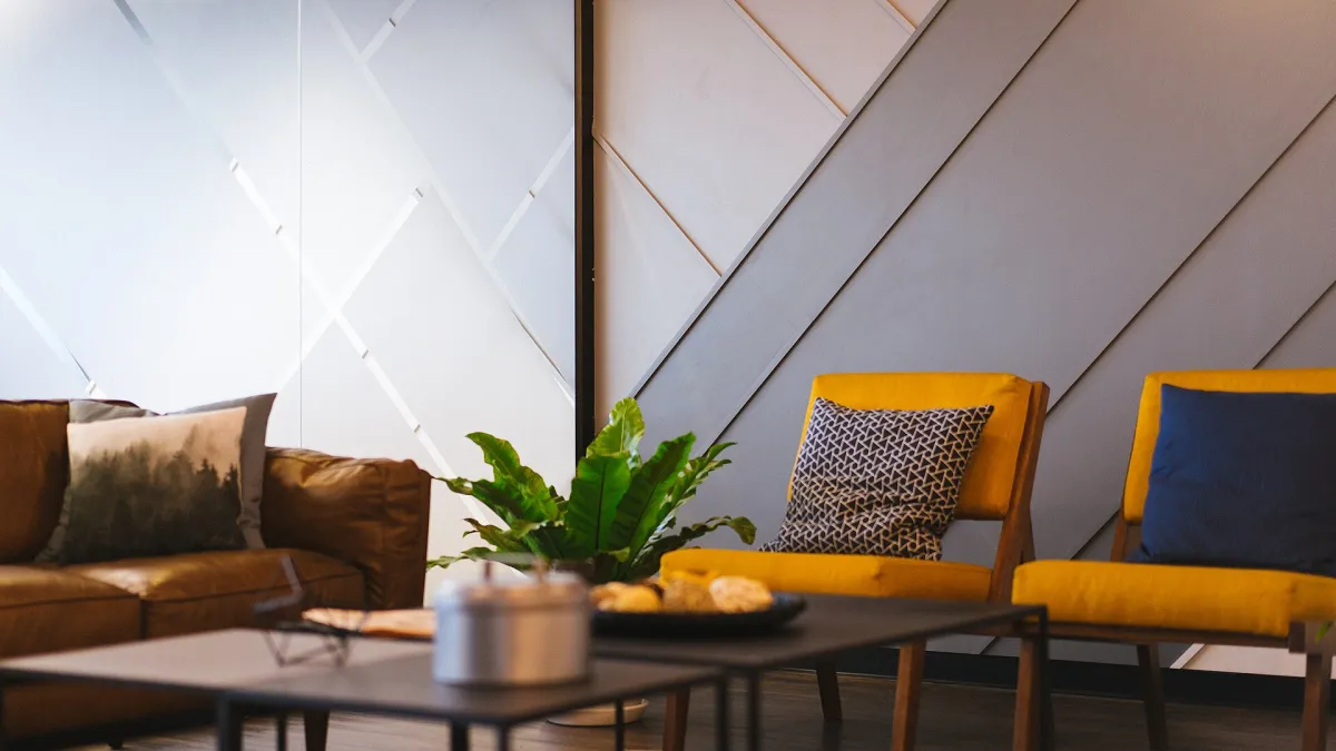 A small meeting room with a table, chairs and a wall-mounted screen in an office