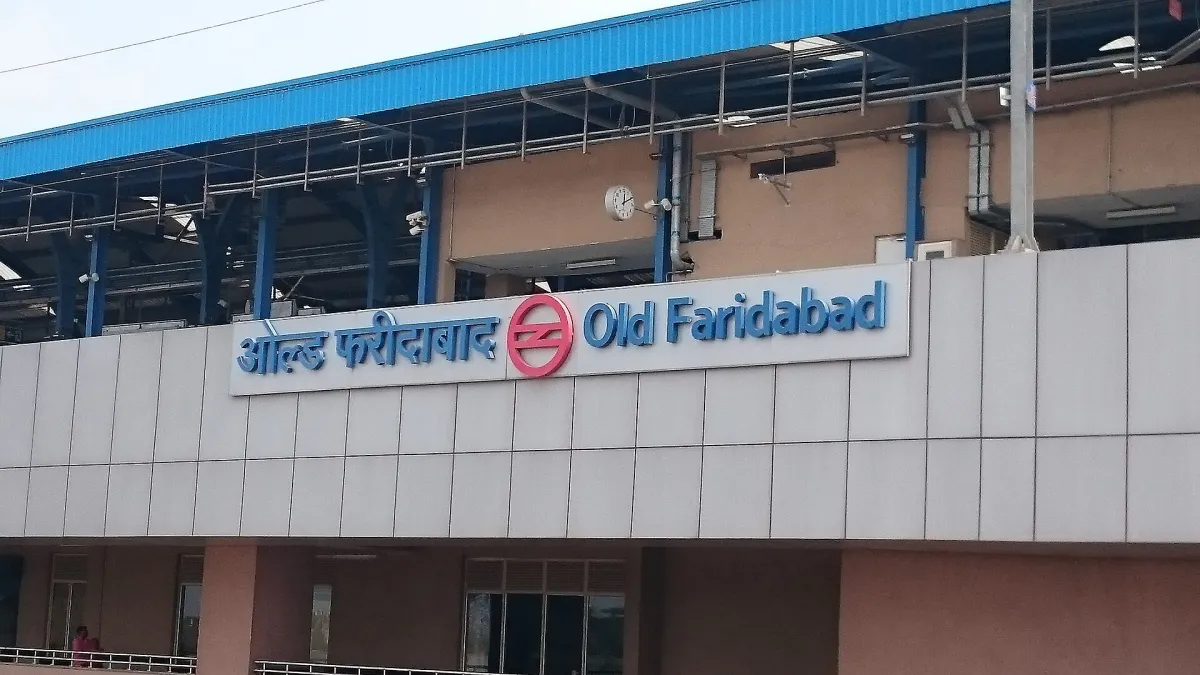 An elevated metro station in Faridabad with the track running above a main road